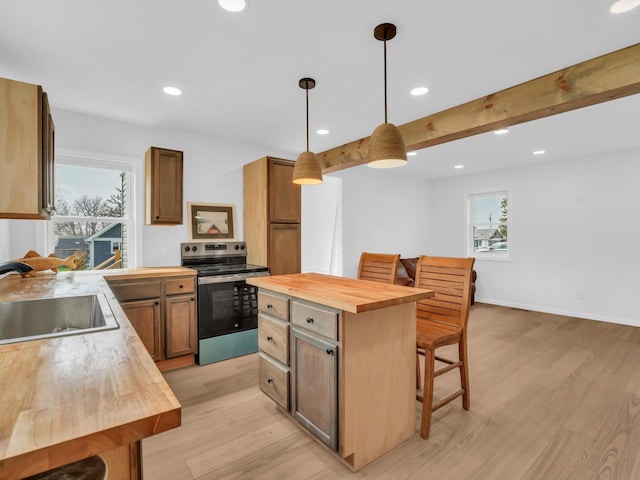 4208 Locust St, Delavan, WI 53115 - kitchen with wooden counters, stainless steel range with electric cooktop, a breakfast bar area, a sink, and light wood-style floors