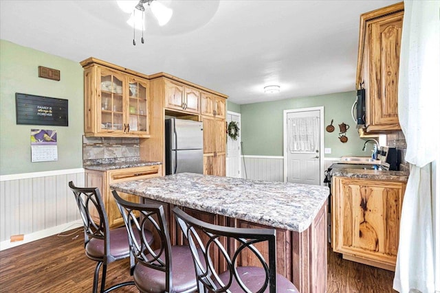 2931 N Ave, Wisconsin Rapids, WI 54495 - kitchen with freestanding refrigerator, a wainscoted wall, dark wood-style flooring, a center island, and glass insert cabinets
