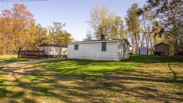 207 State Road 25, Wheeler, WI 54772 - rear view of house featuring a lawn, a chimney, and a wooden deck