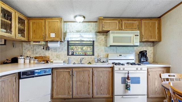 207 State Road 25, Wheeler, WI 54772 - kitchen with white appliances, a sink, wallpapered walls, light countertops, and brown cabinets