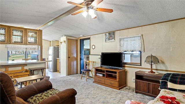 207 State Road 25, Wheeler, WI 54772 - living room featuring a ceiling fan, healthy amount of natural light, a textured ceiling, vaulted ceiling, and carpet flooring