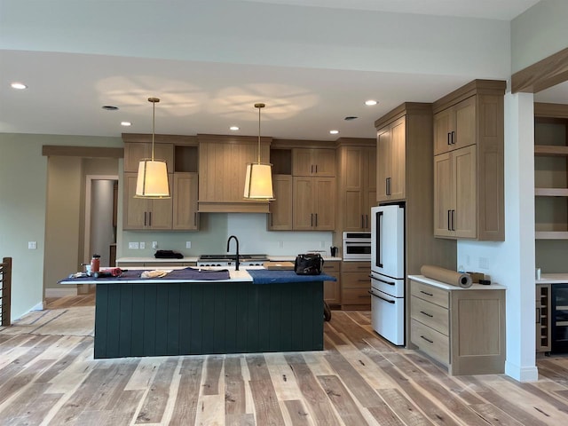 1102 Moll Dr, Waunakee, WI 53597 - kitchen featuring freestanding refrigerator, a center island with sink, light wood-type flooring, stainless steel oven, and recessed lighting