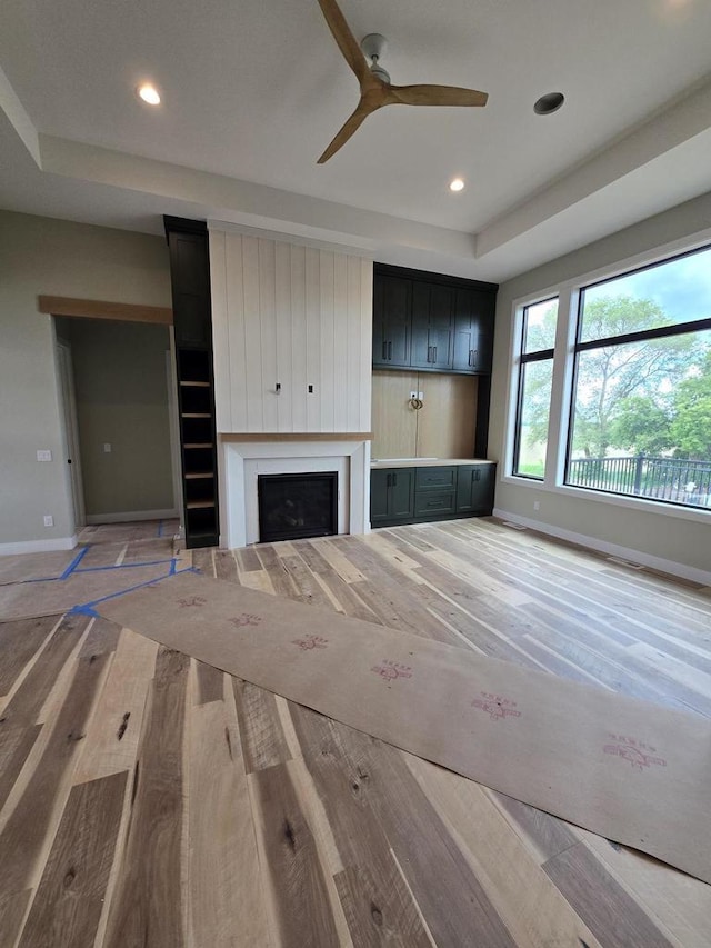 1102 Moll Dr, Waunakee, WI 53597 - unfurnished living room with baseboards, a fireplace, a ceiling fan, recessed lighting, and light wood-style floors