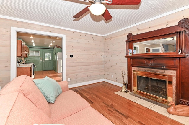2811 Alpine Ln, Delavan, WI 53115 - living room featuring light wood-type flooring, a ceiling fan, wood walls, and a fireplace