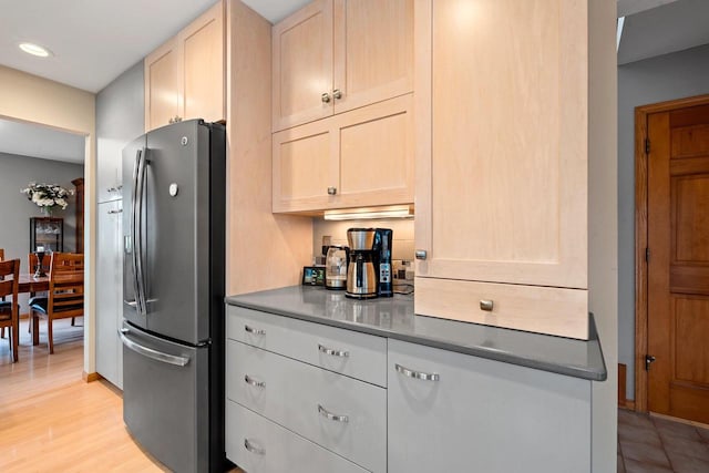 1346 Partridge Ct, Oshkosh, WI 54904 - kitchen with stainless steel fridge with ice dispenser, light wood-style floors, recessed lighting, light brown cabinetry, and dark countertops