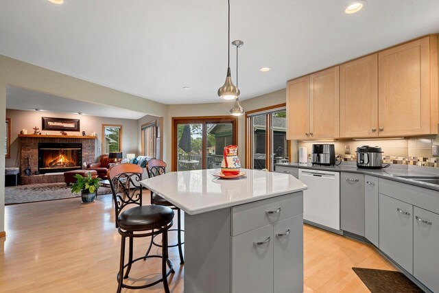 1346 Partridge Ct, Oshkosh, WI 54904 - kitchen featuring white dishwasher, light wood finished floors, light brown cabinets, a breakfast bar area, and recessed lighting