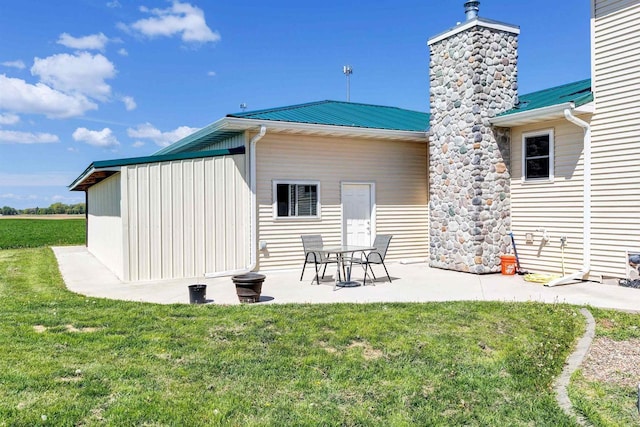 4600 Kamper Ln, Denmark, WI 54208 - rear view of property featuring a yard, a patio, metal roof, and a chimney