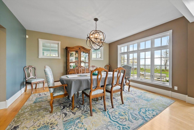 4320 High, Point Beach Lane, Port Washington, WI 53074 - dining room with a chandelier, light wood-style flooring, and baseboards