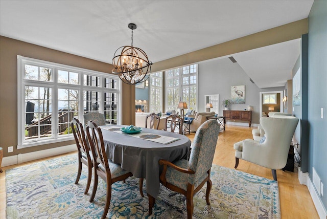 4320 High, Point Beach Lane, Port Washington, WI 53074 - dining room featuring a chandelier, light wood-type flooring, and baseboards