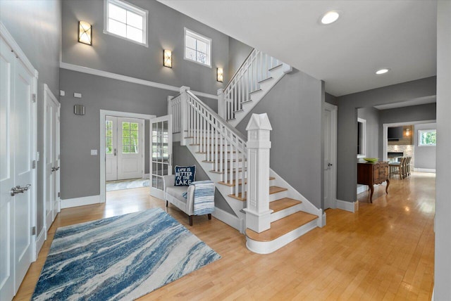 4320 High, Point Beach Lane, Port Washington, WI 53074 - stairs featuring baseboards, wood finished floors, recessed lighting, and a towering ceiling