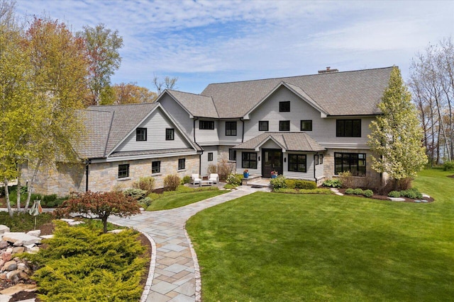 4320 High, Point Beach Lane, Port Washington, WI 53074 - view of front of house with stone siding, a front lawn, a chimney, and a shingled roof