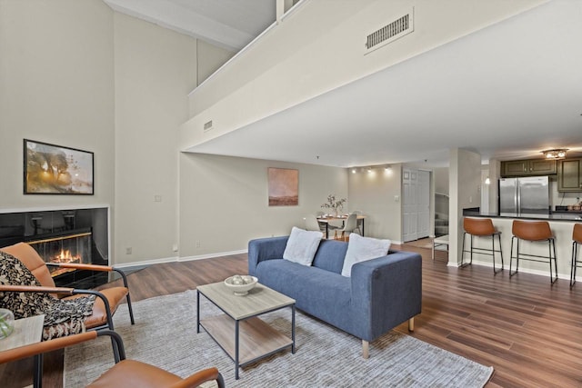 270 E Highland Ave Unit 1031, Milwaukee, WI 53202 - living area with wood finished floors, a glass covered fireplace, baseboards, and a towering ceiling