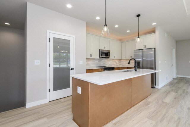 20840 Gray St, Lannon, WI 53046 - kitchen with a sink, stainless steel appliances, backsplash, light wood-style flooring, and baseboards