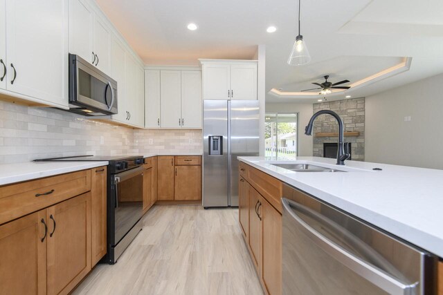 20840 Gray St, Lannon, WI 53046 - kitchen with stainless steel appliances, a sink, light countertops, a tray ceiling, and white cabinets