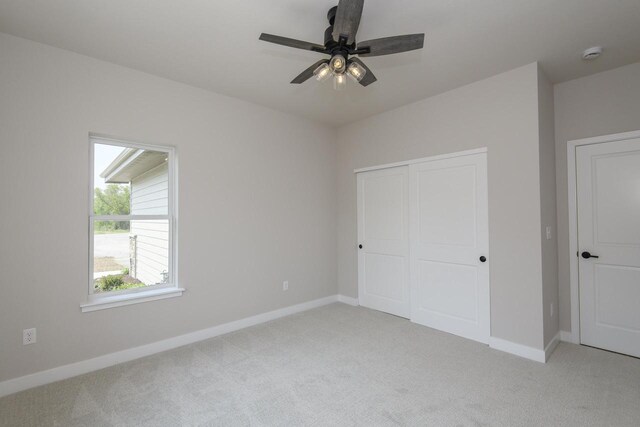 20840 Gray St, Lannon, WI 53046 - unfurnished bedroom with light carpet, baseboards, a closet, and a ceiling fan