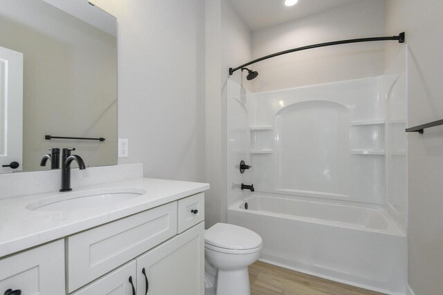 20840 Gray St, Lannon, WI 53046 - full bathroom with vanity, toilet, wood finished floors, and washtub / shower combination