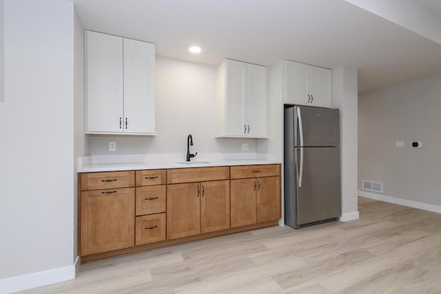 20840 Gray St, Lannon, WI 53046 - kitchen with freestanding refrigerator, a sink, light wood-type flooring, light countertops, and baseboards