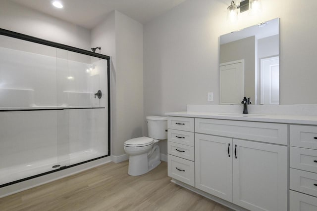 20840 Gray St, Lannon, WI 53046 - bathroom featuring toilet, a stall shower, wood finished floors, vanity, and baseboards