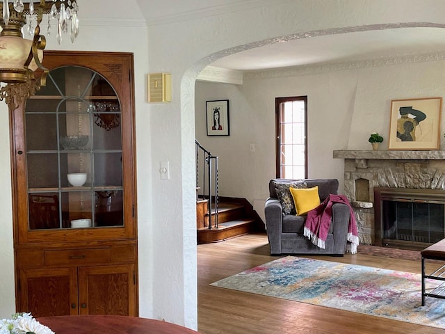 620 W Rock Pl, Glendale, WI 53209 - living area featuring wood finished floors, arched walkways, stairway, ornamental molding, and a stone fireplace
