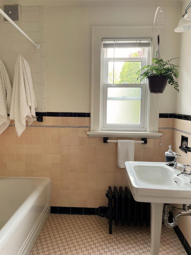 620 W Rock Pl, Glendale, WI 53209 - bathroom featuring tile walls, a tub, a wainscoted wall, and a shower