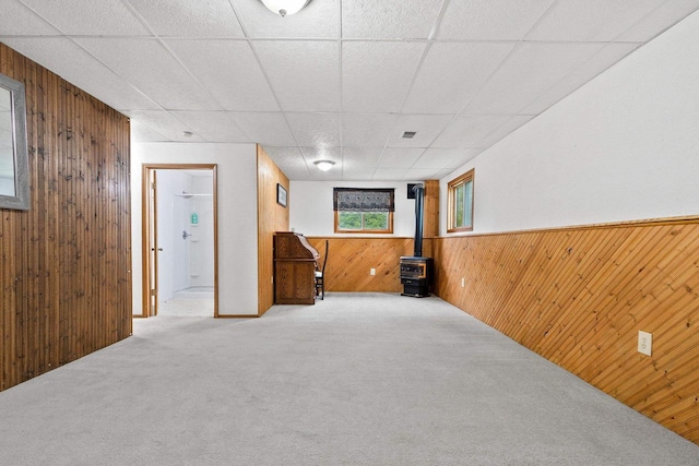 1330 Pinehurst Ln, Neenah, WI 54956 - below grade area with wood walls, a wood stove, carpet floors, and a paneled ceiling