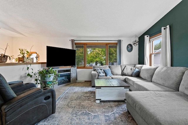 1330 Pinehurst Ln, Neenah, WI 54956 - living room featuring carpet, a textured ceiling, a glass covered fireplace, lofted ceiling, and baseboards
