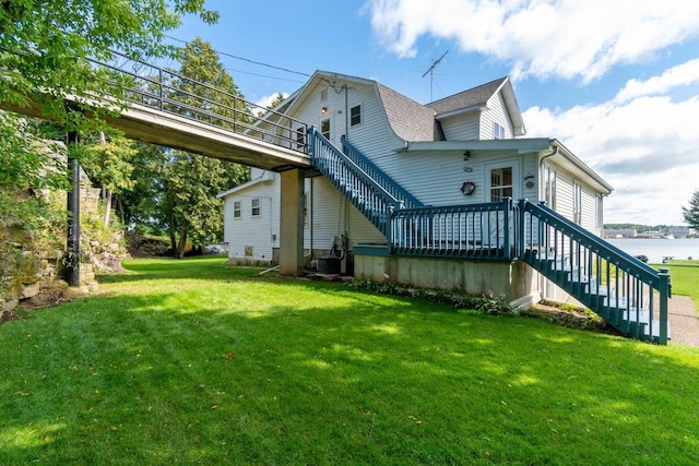 440 N Hudson Ave, Sturgeon Bay, WI 54235 - back of property with stairway, a lawn, a shingled roof, and a wooden deck