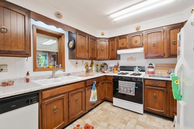 440 N Hudson Ave, Sturgeon Bay, WI 54235 - kitchen with white appliances, a sink, light countertops, under cabinet range hood, and brown cabinetry
