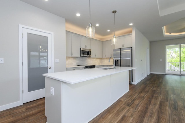 20880 Gray St, Lannon, WI 53046 - kitchen featuring stainless steel appliances, a sink, dark wood finished floors, decorative backsplash, and light countertops