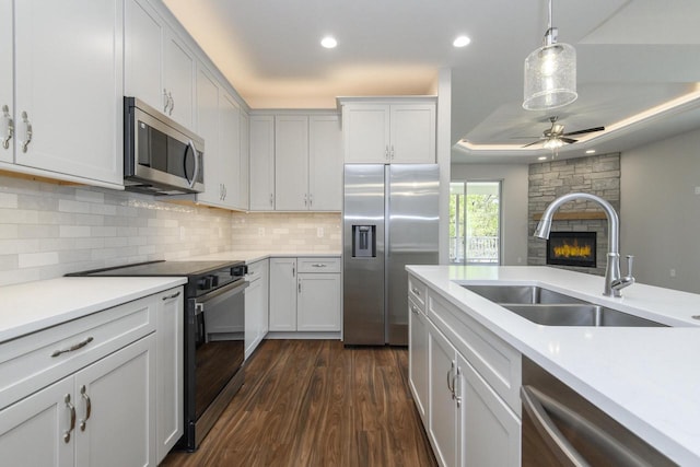 20880 Gray St, Lannon, WI 53046 - kitchen with appliances with stainless steel finishes, a sink, a fireplace, light countertops, and ceiling fan