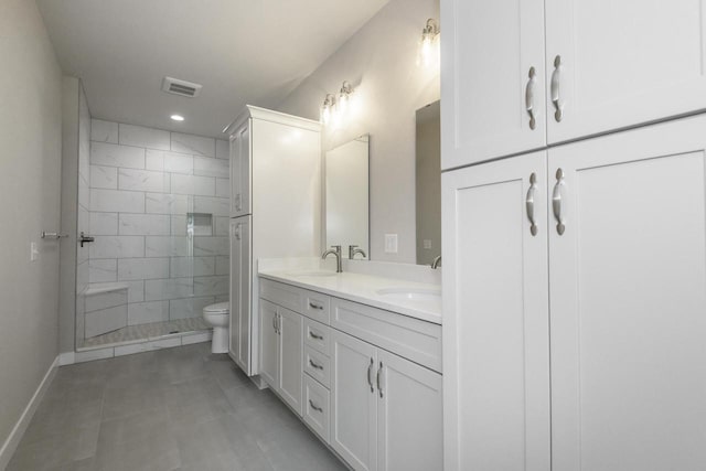 20880 Gray St, Lannon, WI 53046 - bathroom featuring double vanity, toilet, tiled shower, recessed lighting, and baseboards