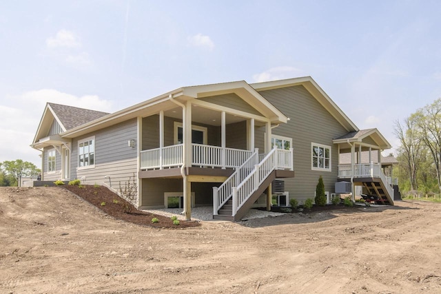 20880 Gray St, Lannon, WI 53046 - rear view of house with stairs, dirt driveway, and covered porch