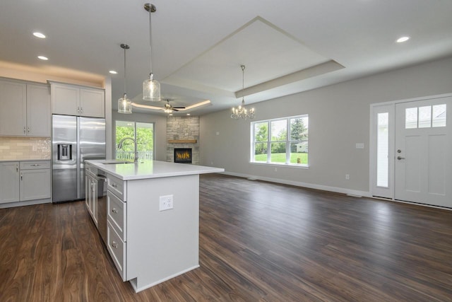 20880 Gray St, Lannon, WI 53046 - kitchen featuring open floor plan, stainless steel appliances, a sink, a fireplace, and ceiling fan