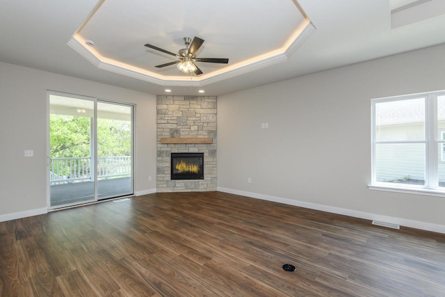 20880 Gray St, Lannon, WI 53046 - unfurnished living room with a tray ceiling, ceiling fan, dark wood-style floors, baseboards, and a fireplace