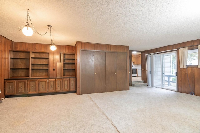 305 N 1st St, Colby, WI 54421 - unfurnished living room featuring wood walls, carpet floors, and a textured ceiling