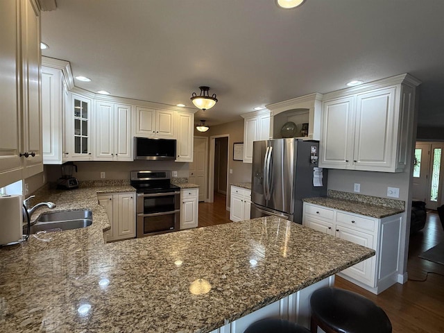 121 Doc Mac Dr, Boscobel, WI 53805 - kitchen with appliances with stainless steel finishes, a sink, a peninsula, white cabinetry, and recessed lighting