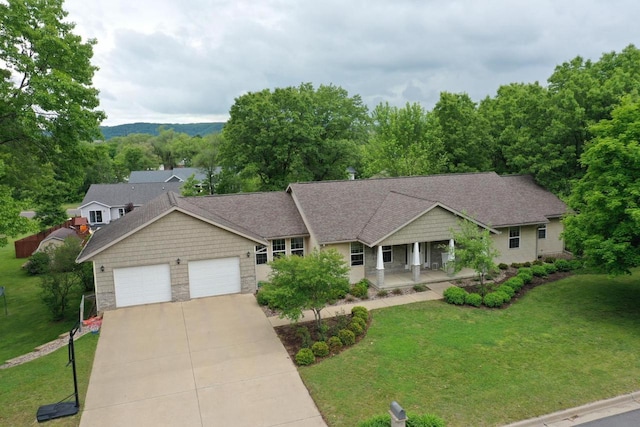 121 Doc Mac Dr, Boscobel, WI 53805 - view of front of property featuring a garage, a front lawn, concrete driveway, covered porch, and stone siding