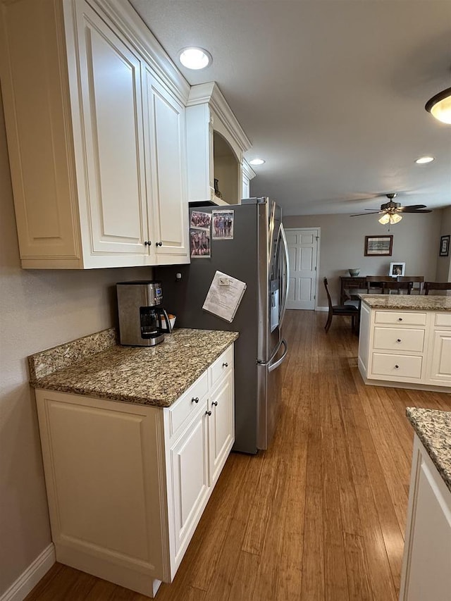 121 Doc Mac Dr, Boscobel, WI 53805 - kitchen with wood finished floors, white cabinetry, baseboards, ceiling fan, and light stone counters