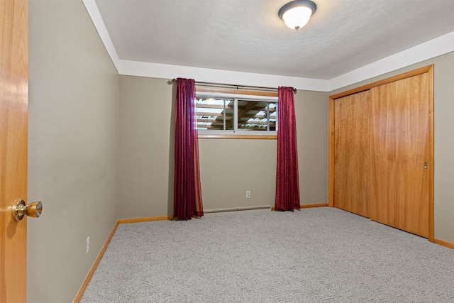 3594 Sunset Dr N, Stevens Point, WI 54482 - unfurnished bedroom with baseboards, carpet, a closet, and baseboard heating