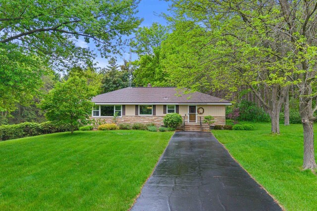 3594 Sunset Dr N, Stevens Point, WI 54482 - single story home with asphalt driveway, a front lawn, and stone siding