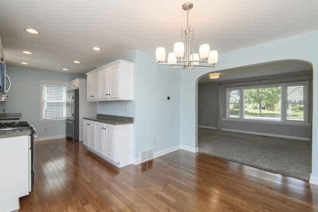 3552 S Pine Ave, Milwaukee, WI 53207 - kitchen with stainless steel appliances, arched walkways, baseboards, white cabinets, and dark wood-style flooring