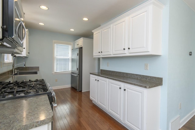 3552 S Pine Ave, Milwaukee, WI 53207 - kitchen with appliances with stainless steel finishes, a sink, baseboards, white cabinetry, and dark wood finished floors