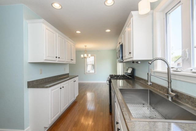 3552 S Pine Ave, Milwaukee, WI 53207 - kitchen with stainless steel appliances, a sink, white cabinetry, baseboards, and recessed lighting