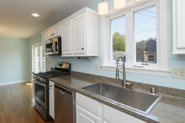3552 S Pine Ave, Milwaukee, WI 53207 - kitchen with appliances with stainless steel finishes, a sink, white cabinets, dark wood finished floors, and recessed lighting