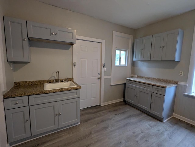110 W Center St, Milwaukee, WI 53212 - kitchen featuring a sink, gray cabinetry, light wood-type flooring, and baseboards