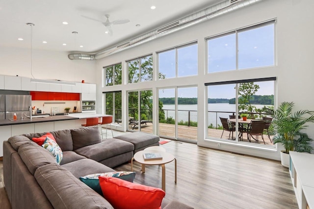 303 Craig Rd, Edgerton, WI 53534 - living area featuring a towering ceiling, a water view, recessed lighting, healthy amount of natural light, and light wood-style flooring