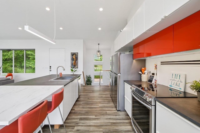 303 Craig Rd, Edgerton, WI 53534 - kitchen with appliances with stainless steel finishes, wood finished floors, white cabinets, recessed lighting, and dark stone counters