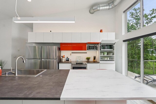 303 Craig Rd, Edgerton, WI 53534 - kitchen with stainless steel appliances, a towering ceiling, an island with sink, and white cabinets