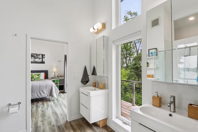 303 Craig Rd, Edgerton, WI 53534 - bathroom with two vanities, a towering ceiling, and wood finished floors