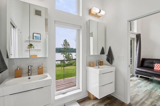 303 Craig Rd, Edgerton, WI 53534 - bathroom with plenty of natural light, vanity, wood finished floors, backsplash, and a towering ceiling